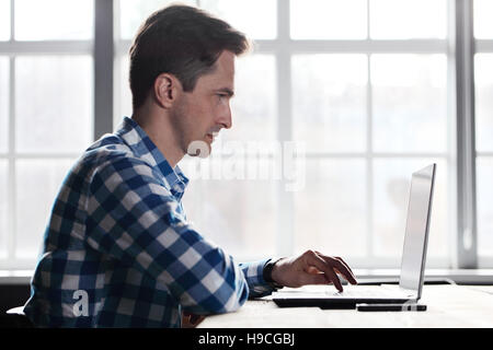 Man working with laptop on wooden table Stock Photo