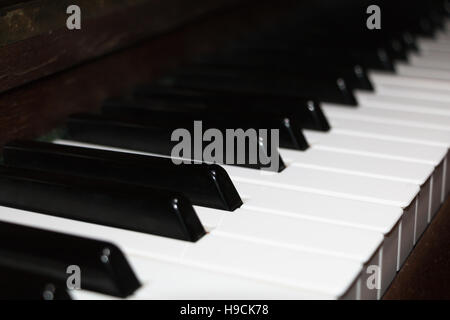 Close-up on an old ivory piano keyboard with a wooden frame Stock Photo