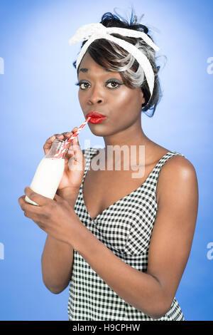 Pin Up girl drinking milk from a retro bottle with straws Stock Photo