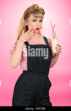 Pin Up girl drinking milk from a retro bottle with straws Stock Photo