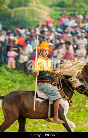 Horsemen at the Pasola, an annual battle where tribes throw spears to spill blood and fertilize the land to ensure a good harvest, on Sumba in Indones Stock Photo