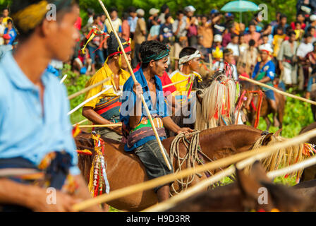 Horsemen at the Pasola, an annual battle where tribes throw spears to spill blood and fertilize the land to ensure a good harvest, on Sumba in Indones Stock Photo