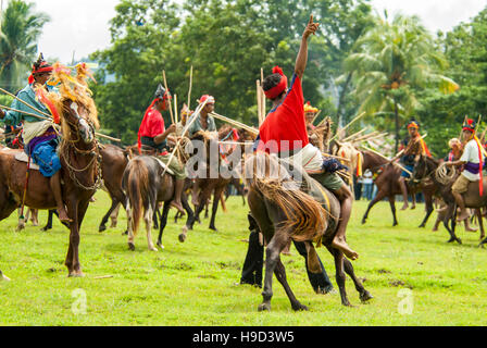 Horsemen at the Pasola, an annual battle where tribes throw spears to spill blood and fertilize the land to ensure a good harvest, on Sumba in Indones Stock Photo