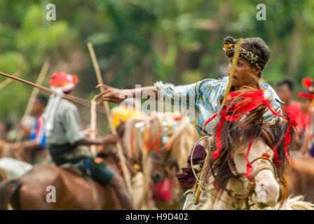 Horsemen at the Pasola, an annual battle where tribes throw spears to spill blood and fertilize the land to ensure a good harvest, on Sumba in Indones Stock Photo