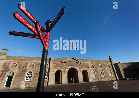 Fort George Scotland. Visitor direction signpost, with Fort George’s main entrance and guardrooms in the background. Stock Photo