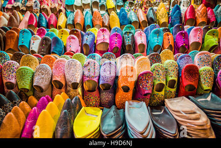 Brightly coloured traditional leather, hand made moroccan slippers on sale in the souk Stock Photo