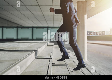 Businessman running fast upstairs. Horizontal outdoors shot. Stock Photo