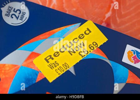 Close up of yellow reduced label sticker on pack of chilled fish salmon fillet fillets England UK United Kingdom GB Great Britain Stock Photo