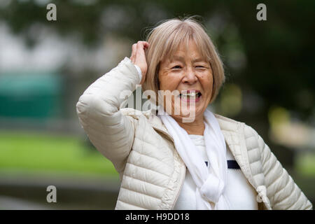 Happy elderly Japanese woman laughs and scratches her head Stock Photo