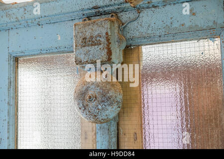 An metal alarm bell mounted on a middle section of a window. Stock Photo