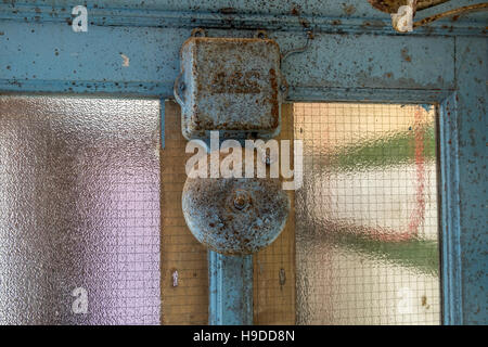 An metal alarm bell mounted on a middle section of a window. Stock Photo