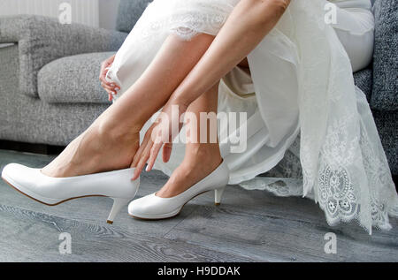 Bride putting her shoes on Stock Photo