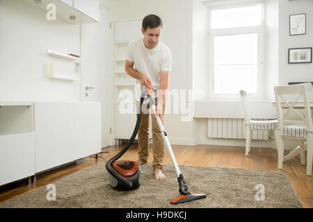 Happy smiling man cleaning the carpet Stock Photo