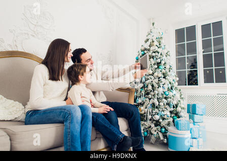 christmas, holidays, technology and people concept - smiling family with tablet pc taking selfie at home Stock Photo