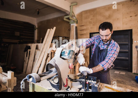 Carpenter Using Circular Saw for wood at his workshop Stock Photo