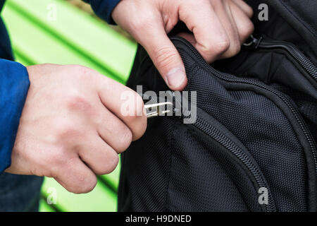 Close up view of hand closing  zipper on backpack , bag Stock Photo