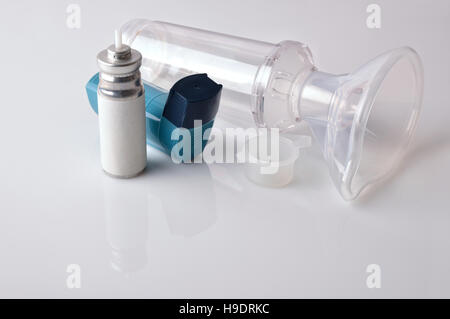 Cartridge, blue medicine inhaler, inhalation chamber and silicone mask isolated on white glass table. Elevated view. Horizontal composition Stock Photo