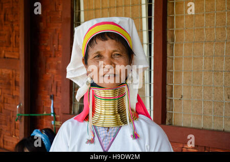 Padaung 'long necked' woman, wearing the traditional metal rings around her neck, weaving on a loom Stock Photo