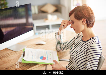 Tired woman browsing some documents Stock Photo