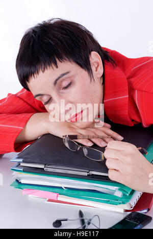 Exhausted businesswoman sleeping on a pile of files in the office Stock Photo
