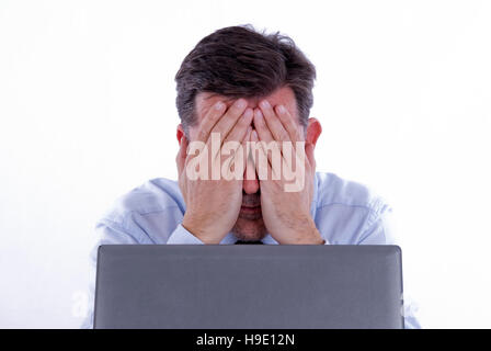 Despairing businessman, working on a computer Stock Photo