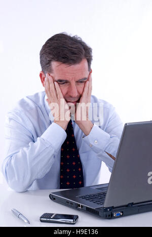 Desperate businessman, over 50, working on a laptop Stock Photo