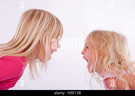 Two blonde girls screaming at each other Stock Photo