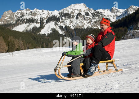 Man and children on a sledge Stock Photo