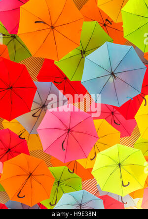 Colorful umbrellas hanging from a roof, creating an interesting abstract background. Stock Photo