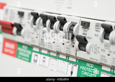 An RCD circuit breaker board displays many switches. Most are in the ON position, but one is switched down to OFF. It is the circuit for the lighting Stock Photo