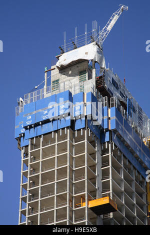 Protective climbing screens surround the top of a new, concrete framed tower block as it is constructed in Central London, UK Stock Photo