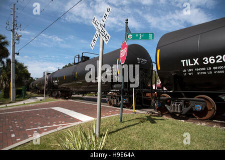 Mount Dora Florida USA -  Railroad freight train hauling liquid carrying trucks passing over unmanned crossing Stock Photo