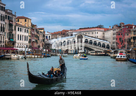 Couple enjoying a gondola ride at Canal Grande, near the Rialto Bridge, in Venice. Stock Photo