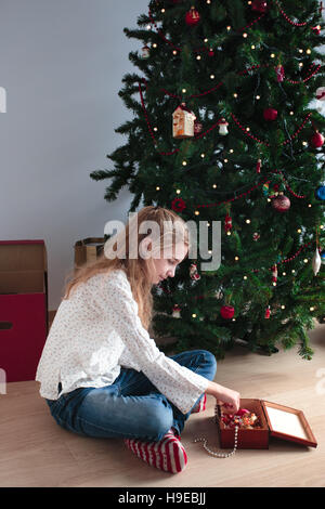 Young girl decorating Christmas tree at home Stock Photo