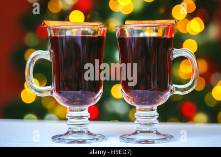 Beautiful Two glasses of mulled wine on bokeh background decorated Christmas tree. The idea for postcards. Soft focus. Shallow DOF Stock Photo