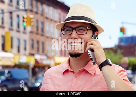 Hispanic man talking on cell phone in city Stock Photo