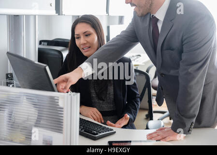 Business people talking in office using computer Stock Photo