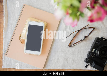 Camera, cell phone, purse, notebook and wallet on table Stock Photo