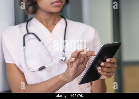Mixed Race nurse using digital tablet