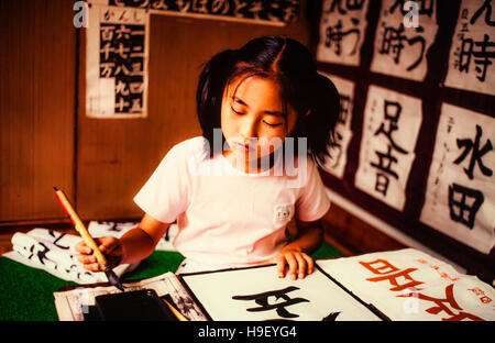 Girl drawing Japanese script Stock Photo