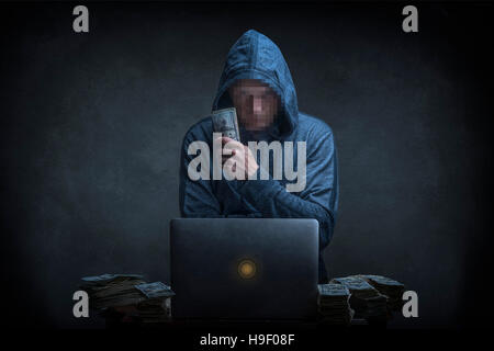 Caucasian hacker stealing money from laptop Stock Photo