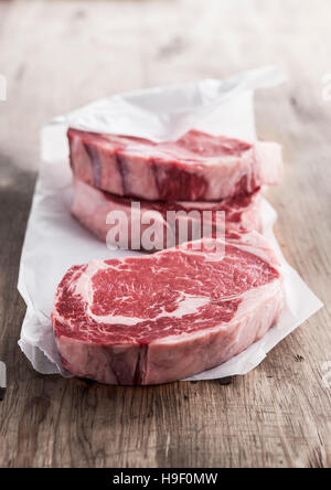 Raw rib eye steaks on butcher paper Stock Photo