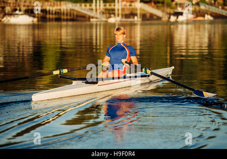 Caucasian man rowing on river Stock Photo
