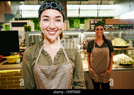 Portrait of smiling Mixed Race workers in food court Stock Photo