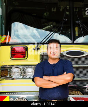 Smiling Chinese fireman posing with fire truck Stock Photo