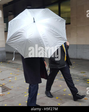 Bookmaker Sanjeev Chawla (left)allegedly implicated in cricket match-fixing involving late South African captain Hansie Cronje, under an umbrella as he leaves Westminster Magistrates' Court following a hearing where he head that will have to wait until next year to learn if he will be extradited to India. Stock Photo