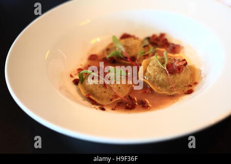 Cabbage ravioli with crispy bacon and pepper sauce Stock Photo