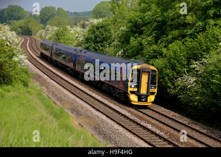 A British Rail Class 158 Express Sprinter train in First Great Western Livery passes Sherrington village in Wiltshire, UK. Stock Photo