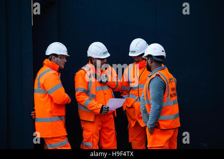 Groundsmen construction site workers in high visibility jackets on a building site, london Stock Photo