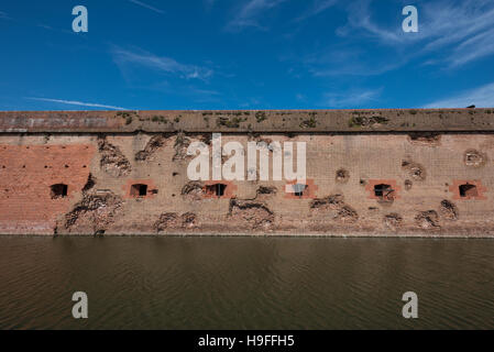 Damaged Wall and Moat at Fort Pulaski with blue sky Stock Photo